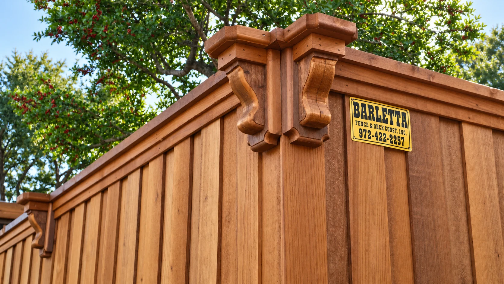 A cedar fence with decorative posts and a Barletta Fence plate