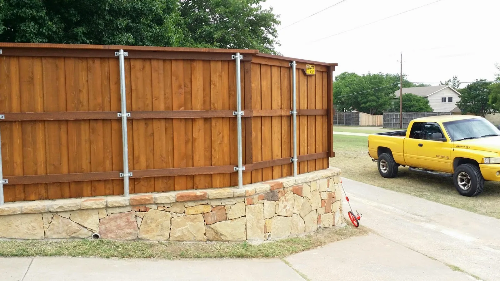 Cedar privacy fence on a stone wall