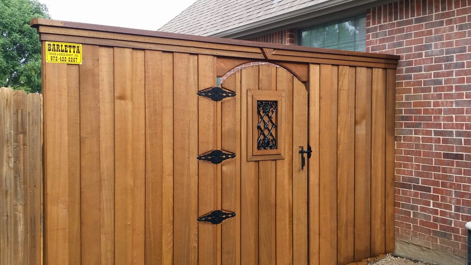 Cedar gate with an arched top and decorative metal insert