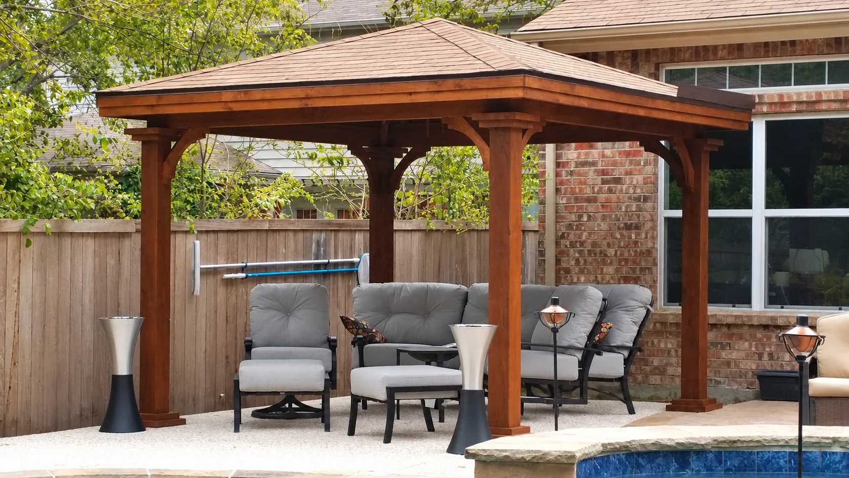 Wood gazebo beside a backyard pool