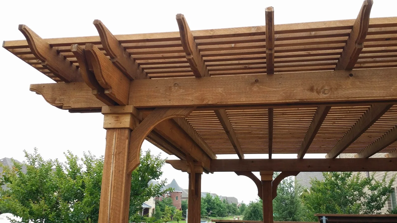 Wood pergola with detailed beams and slatted roof